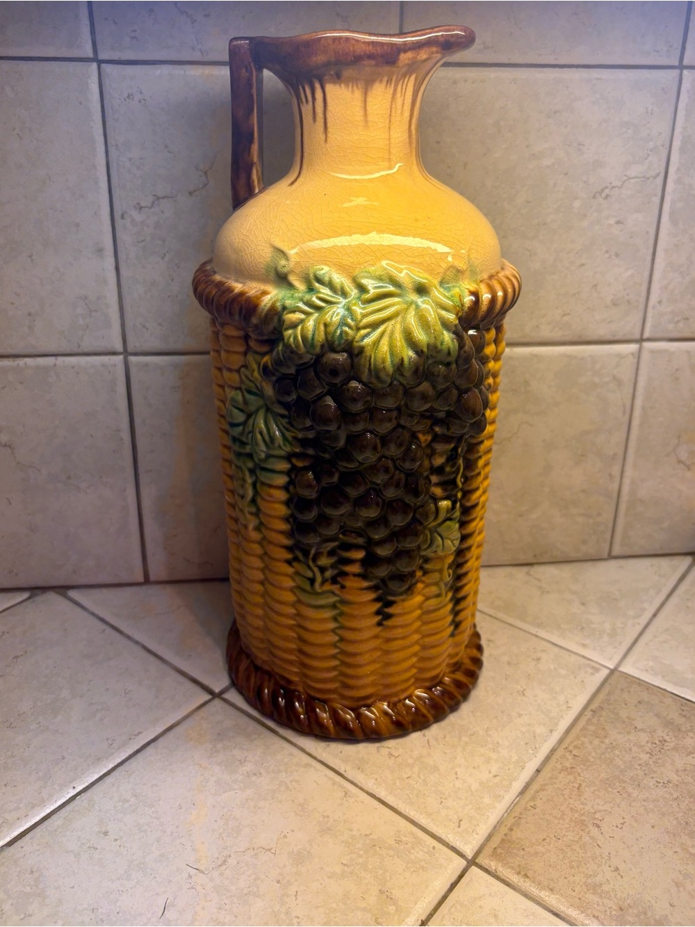 Majolica style ceramic vase featuring an embossed grape and basket weave motif.
